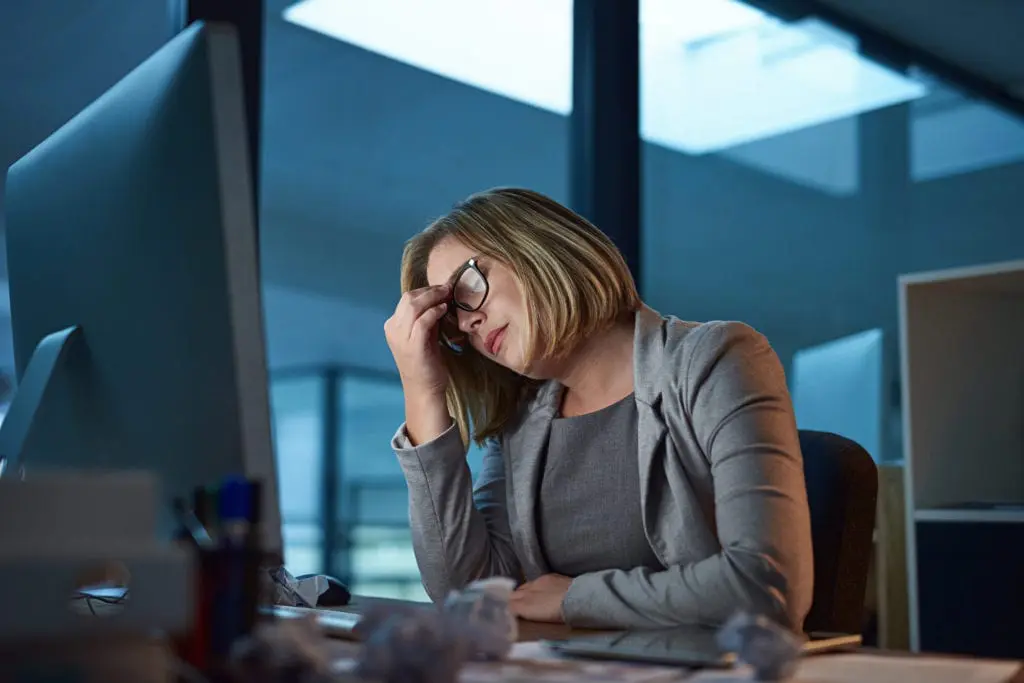 businesswoman looking stressed while working late in the office
