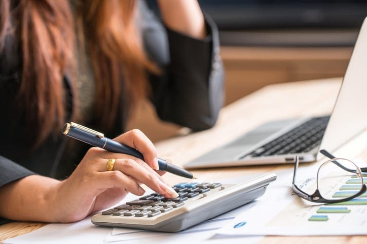 professional woman typing on calculator