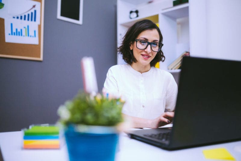 happy professional woman looking at laptop screen