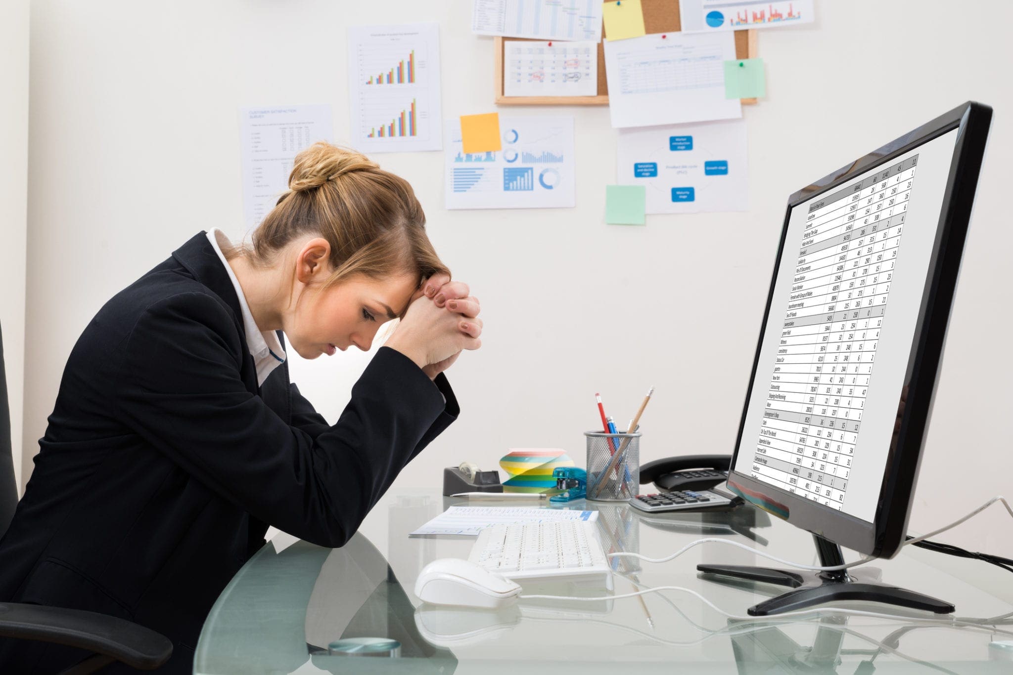 stressed professional woman sitting at computer screen