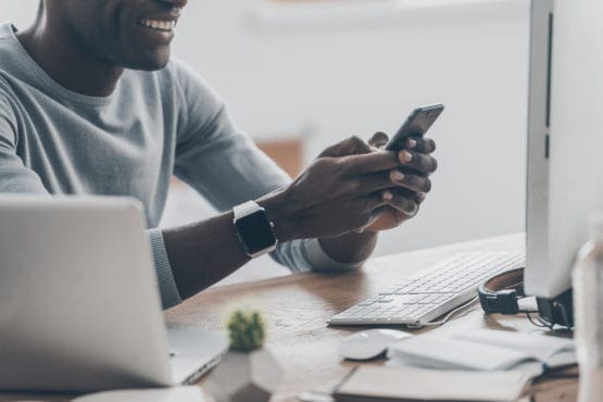 casually dressed man texting at office