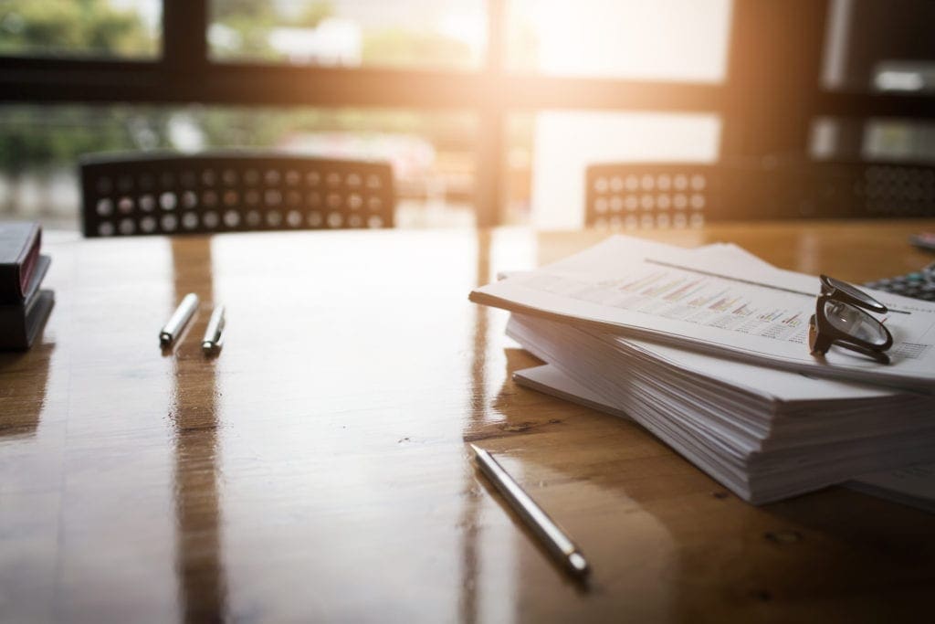 conference table with stack of papers on it