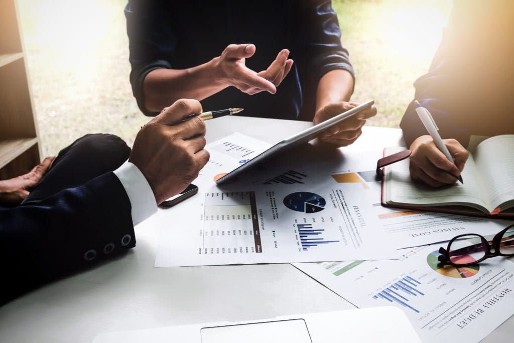 business professionals at conference room table reviewing documents