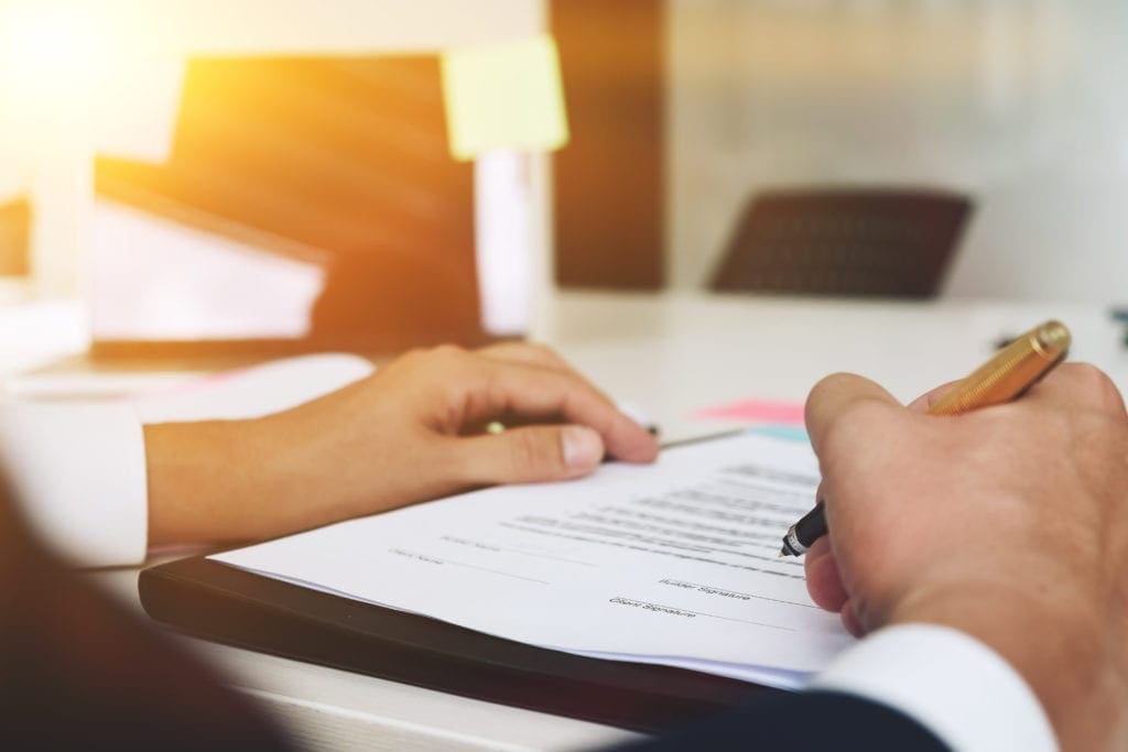 business man hands holding pen writing on papers