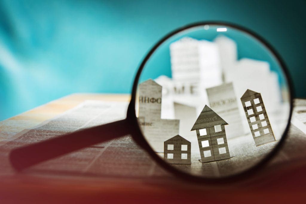 Paper house under a magnifying lens