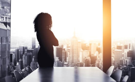 female executive standing in front of conference room window