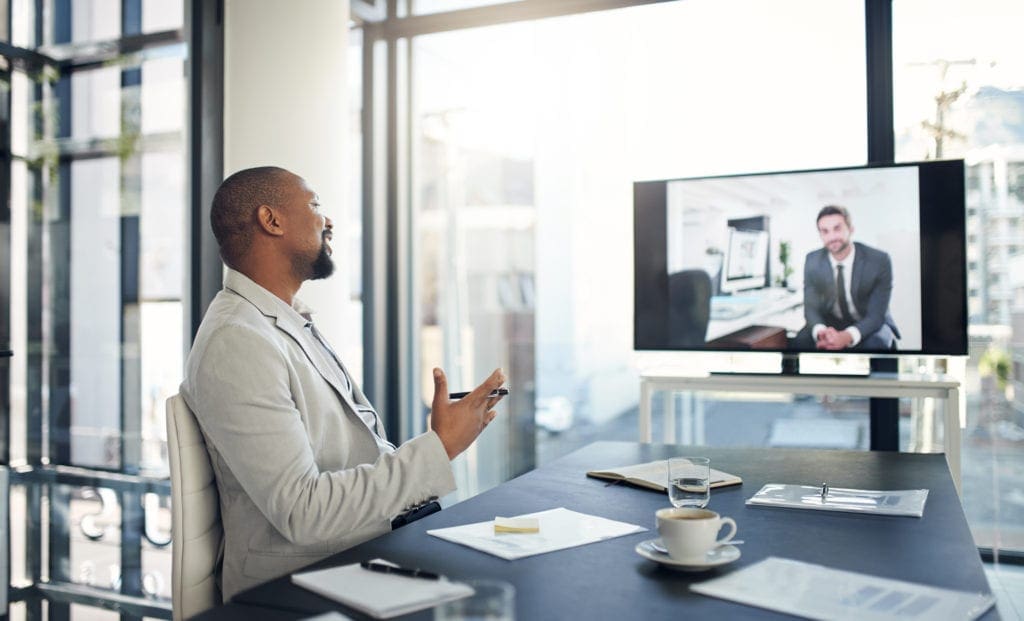 Shot of two businessmen having a video conference used by AvidXchange in article about managing the stress of changing work environments
