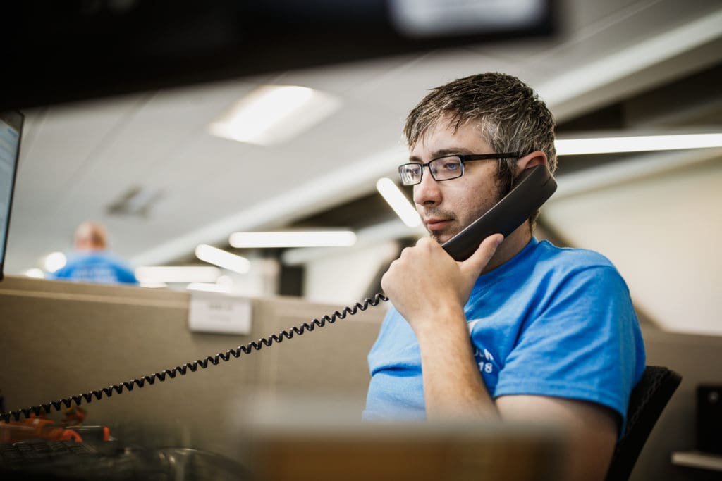 Man speaking on the phone at his desk.