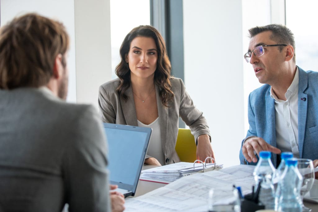 Businessman explaining project in front of him on the conference table to colleagues in a meeting