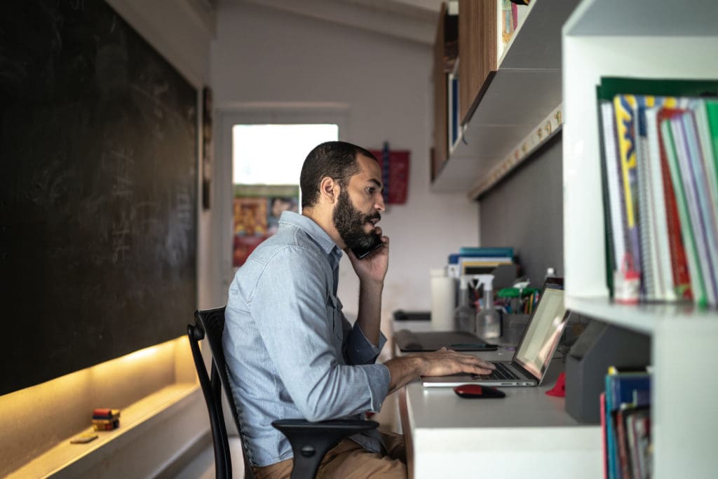 Men talking on the phone while working from home
