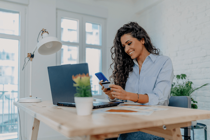 woman at desk on cell phone