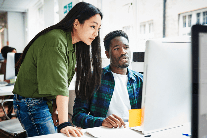 man and woman working at computer