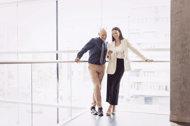 Man and woman talking inside an office building.