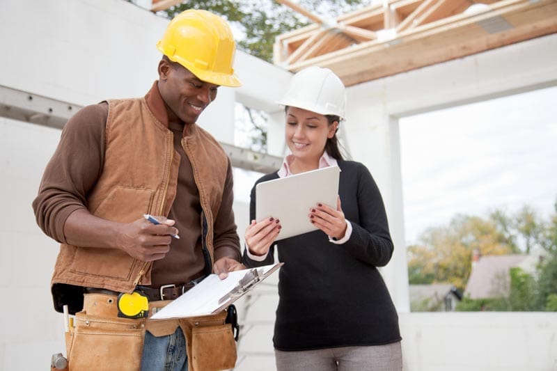 Construction pros reviewing a payment on a tablet at the jobsite