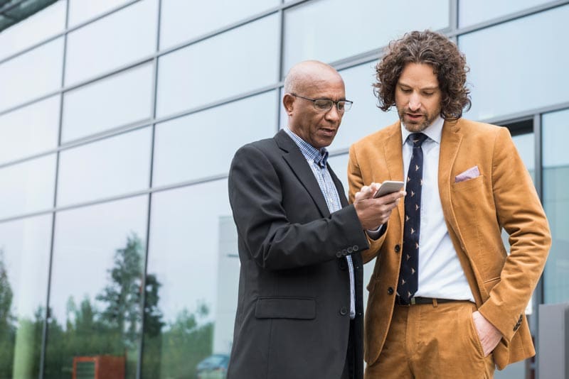 Real estate professionals chatting outside of a modern building