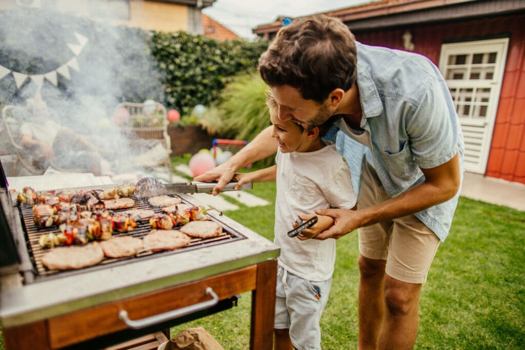 man and daughter grilling outside