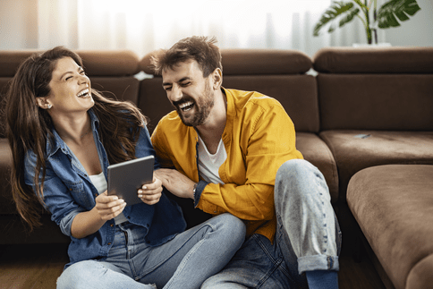 man and woman laughing near couch at build-to-rent home