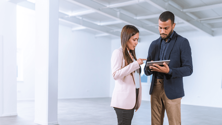 man and woman working in empty building