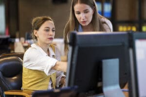 Two women collaborating on a computer.