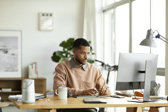 man sitting at desk working on computer