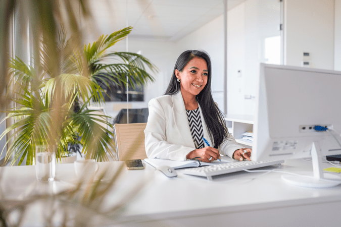 woman sitting at desk and working on computer