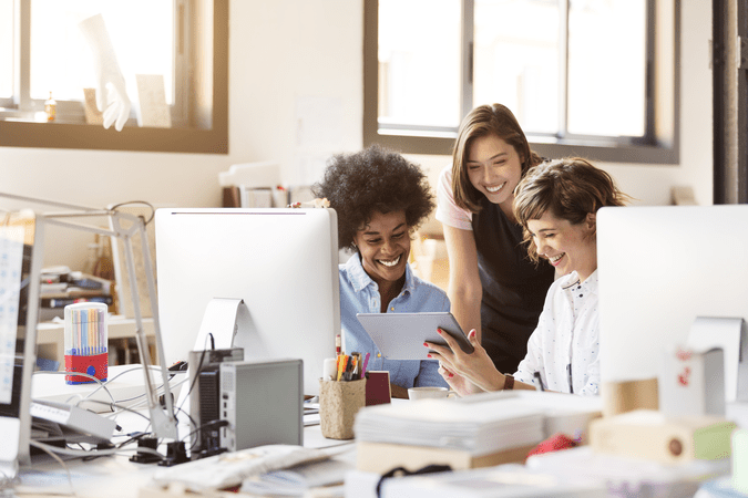 coworkers looking at a computer in an office