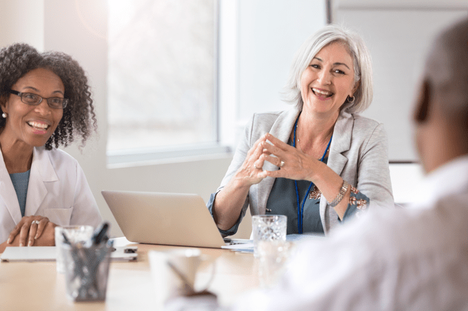 woman in white coat and others in a meeting