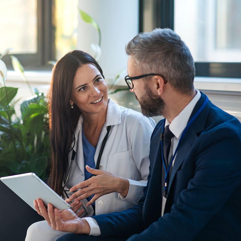 Female doctor speaking with a business manager.