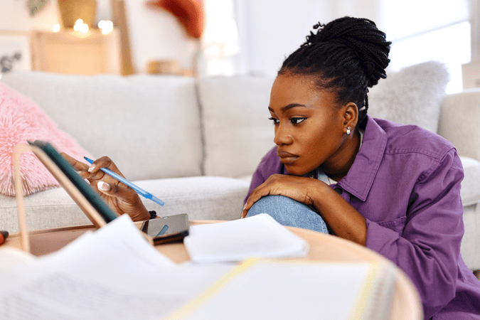 woman balancing her bills on a tablet at home