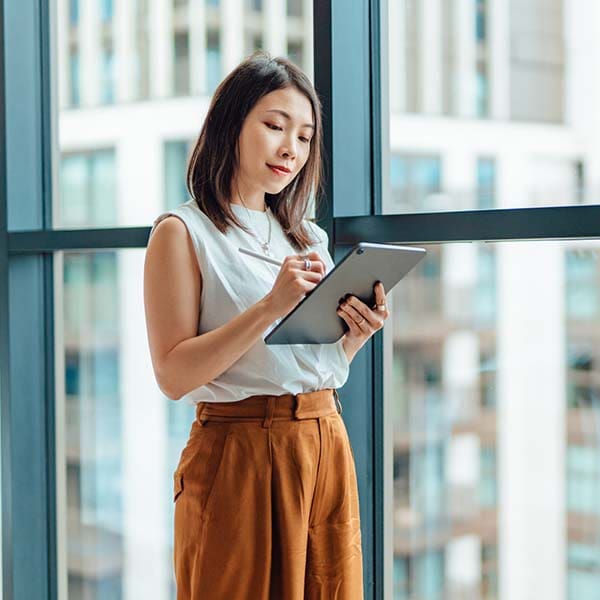 A young businesswoman working on her tablet and smiling.