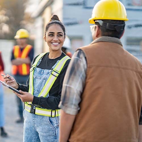 A female contractor speaking with a male construction worker.