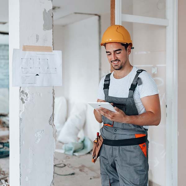 Handyman looking at his tablet and smiling.