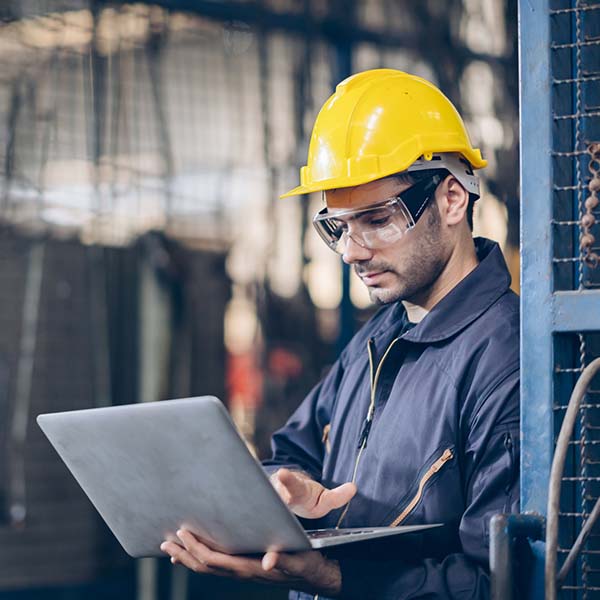 Mechanical engineer on a job site working on his laptop.