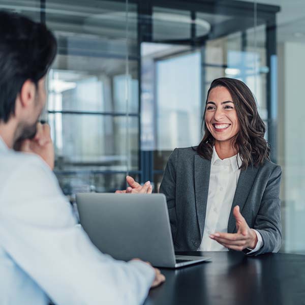 Woman smiling speaking with a male client.