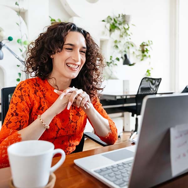 Transgender woman smiling while on a video call with their business partner.