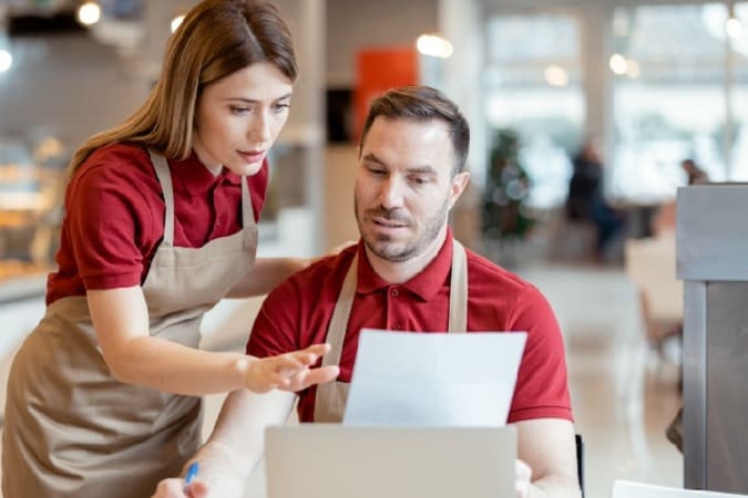 food service workers looking at computer