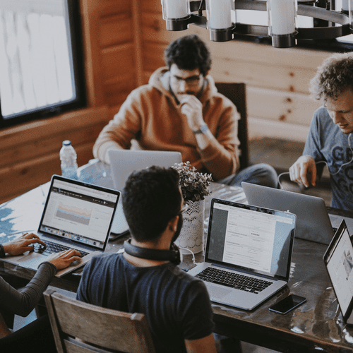 men working at a table on laptops