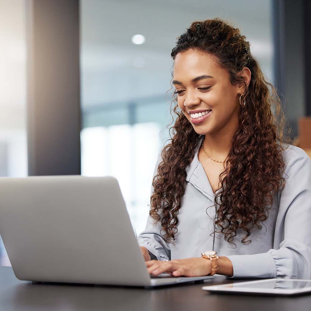 Smiling woman working on her laptop.