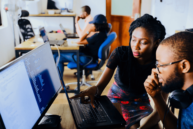 woman and man looking at computing screens at work.
