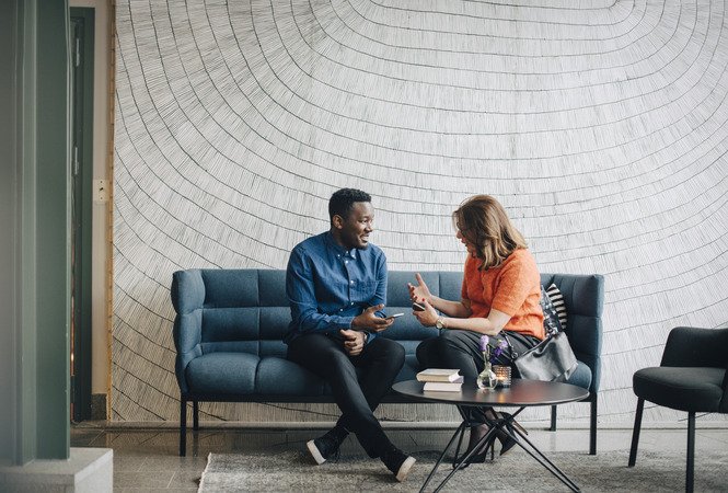 Male and female coworkers looking at a laptop