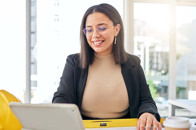 Woman working on her laptop and smiling.