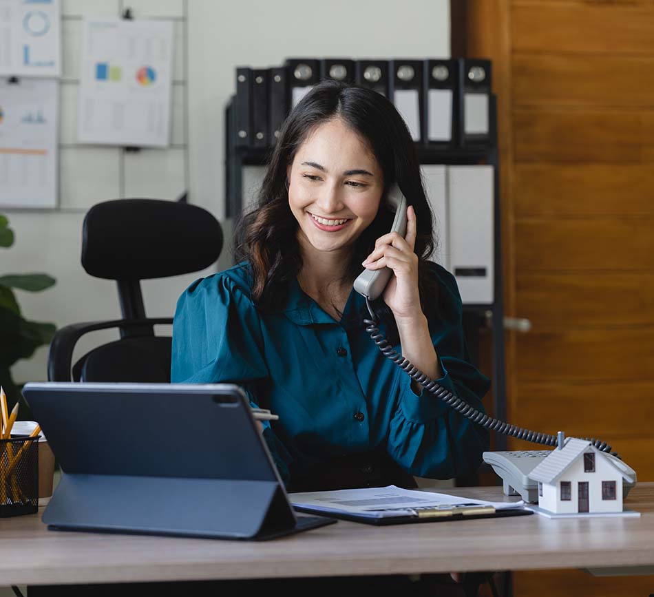 Real Estate investor on the phone with a client, smiling.