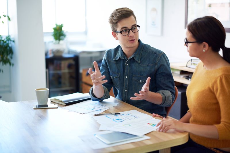 Cropped shot of two coworkers having a discussion in the office about economic uncertainty
