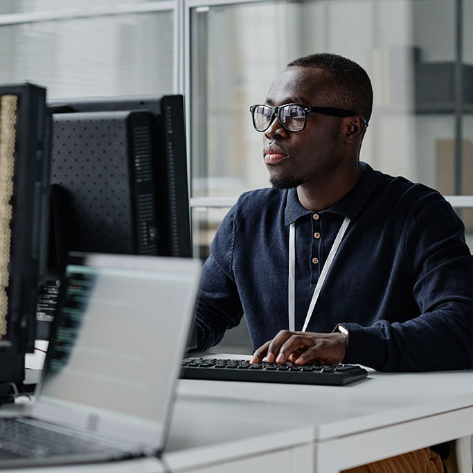 IT tech working at his desk writing an API.