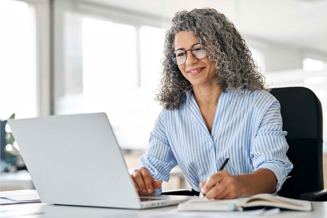 Woman wearing glasses working on laptop