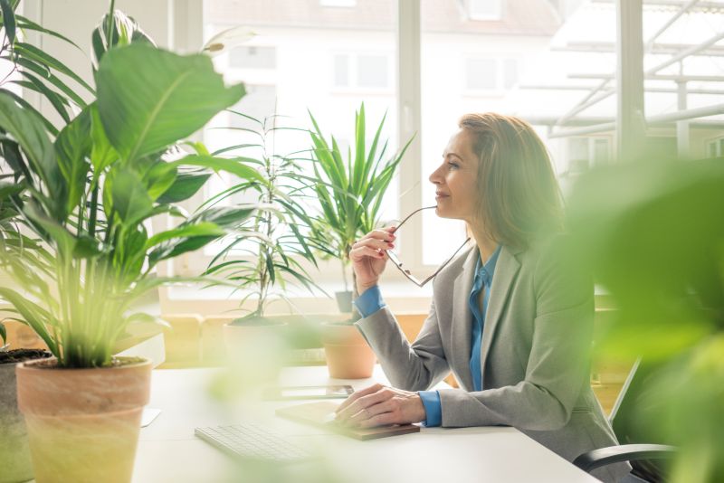 Business woman in bright office contemplates if it's time to automate her real estate accounts payable