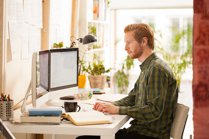 Photo of worker sitting at desk on computer.