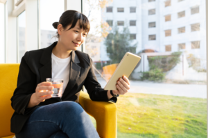 A business woman looking at a tablet computer and smiling
