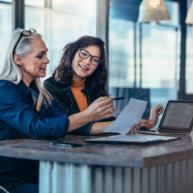 Two professional females reviewing a financial statement