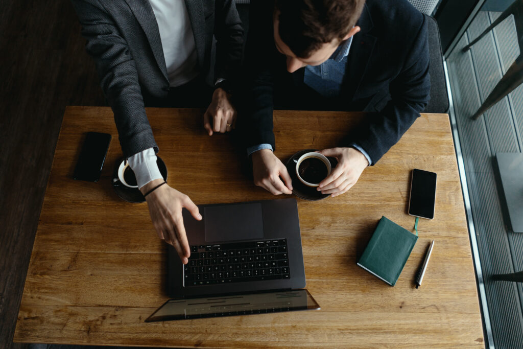 Two businessmen pointing laptop screen